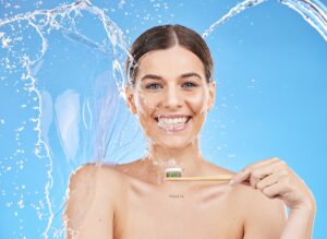 Woman with water splash, dental hygiene and toothbrush with smile, toothpaste and for brushing teet